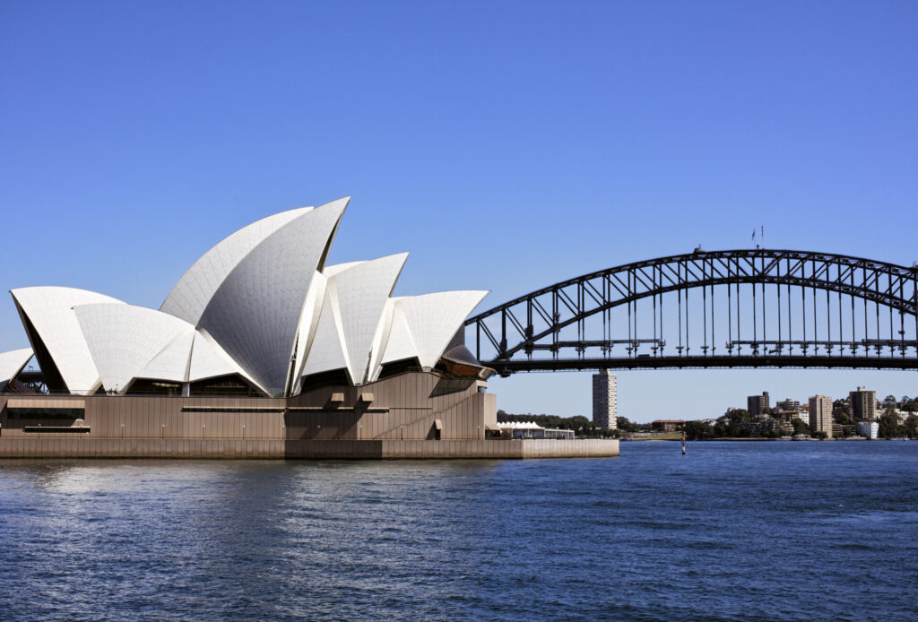 Sydney Opernhaus und Harbour Bridge bei klarem blauen Himmel, ikonische Wahrzeichen Australiens.