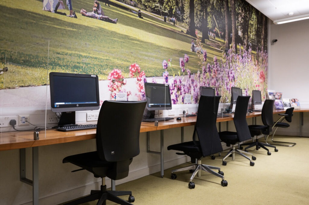 Moderner Computerraum mit Schreibtischen und ergonomischen Stühlen in einer Sprachschule.