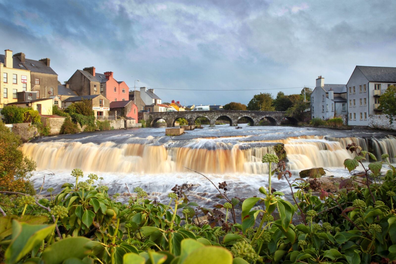 Malerischer Wasserfall und historische Steinbrücke in Ennistymon, Irland.