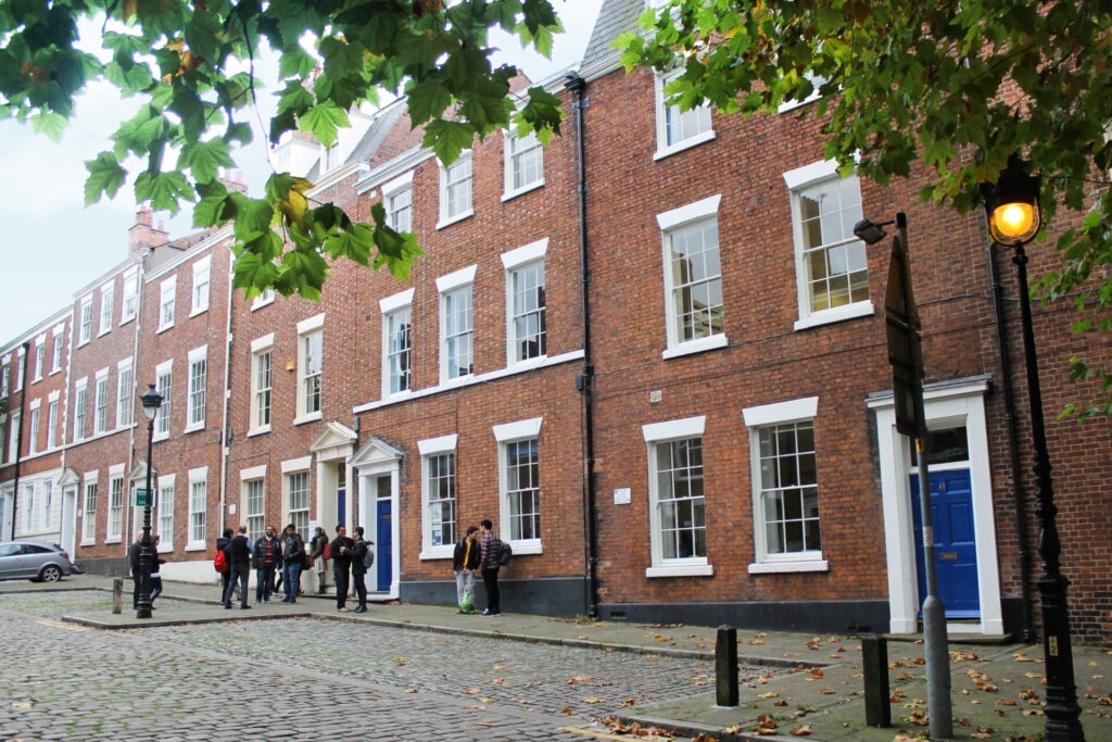 Historische Backsteingebäude in Chester mit einer Gruppe von Studenten, die vor einer Sprachschule stehen.