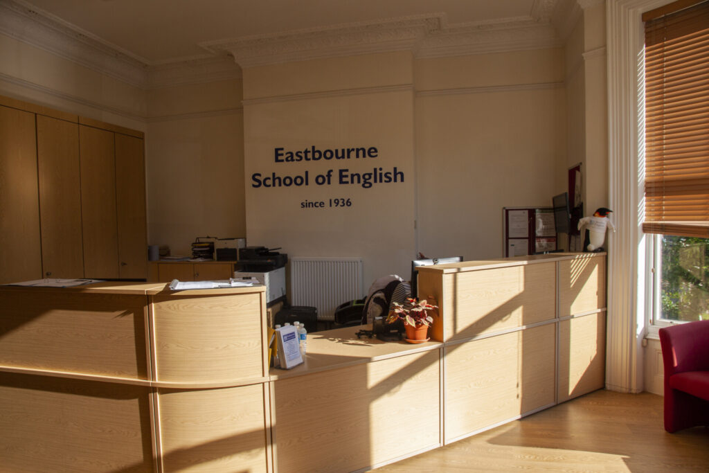 Empfangsbereich der Eastbourne School of English mit moderner Rezeption, hellen Holzmöbeln und freundlicher Atmosphäre.