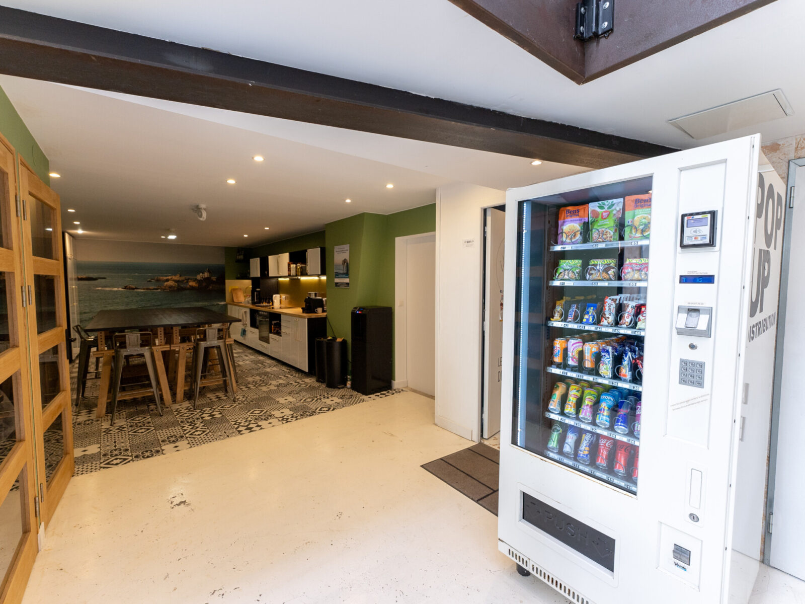 Moderne Gemeinschaftsküche mit Snack- und Getränkeautomat in einem Coworking-Space.