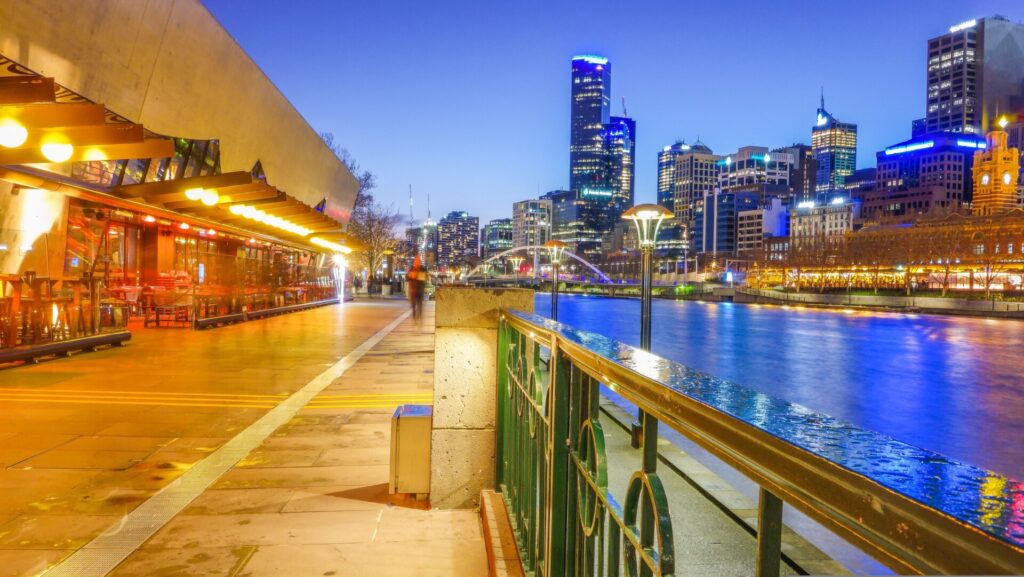 Nächtliche Skyline von Melbourne mit reflektierenden Lichtern am Yarra River.