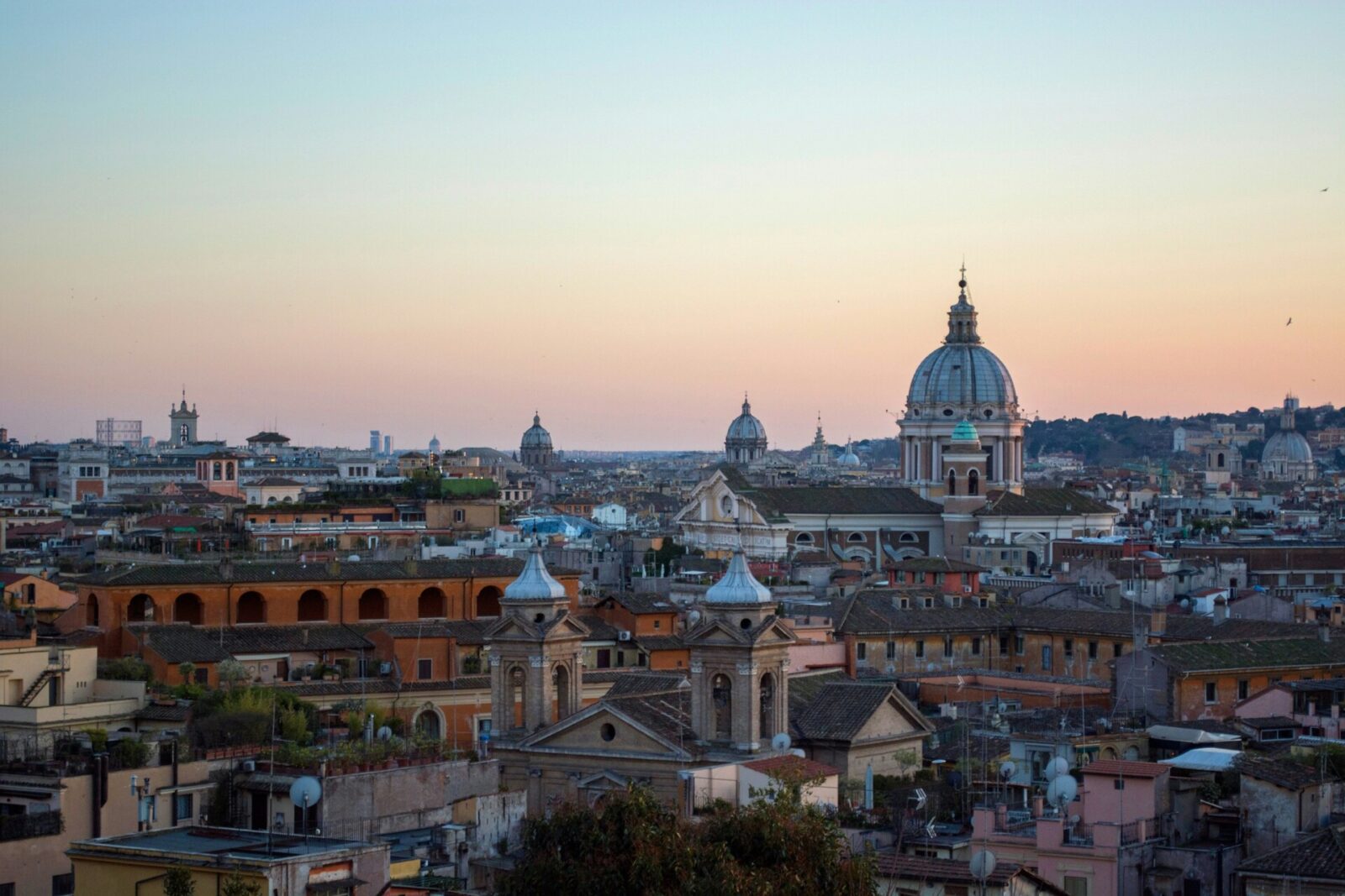 Rom Panorama bei Sonnenuntergang mit historischen Kuppeln und Stadtlandschaft.