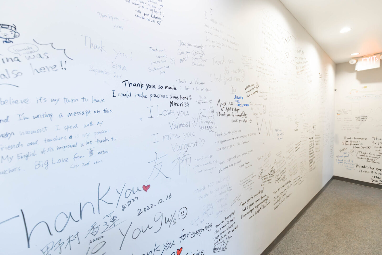Weiße Wand mit handgeschriebenen Botschaften und Dankesnachrichten von Studierenden.