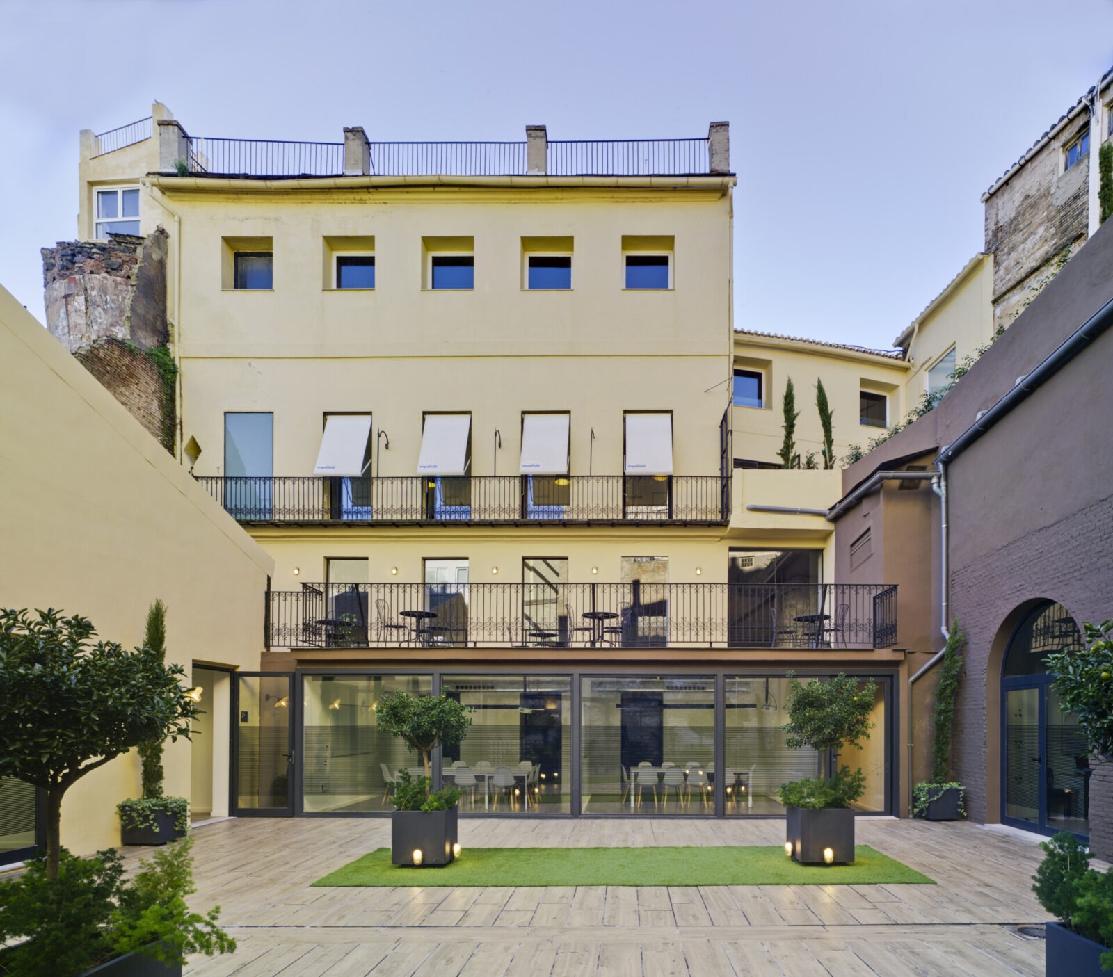 Innenhof mit moderner Terrasse und historischem Gebäude im Hintergrund