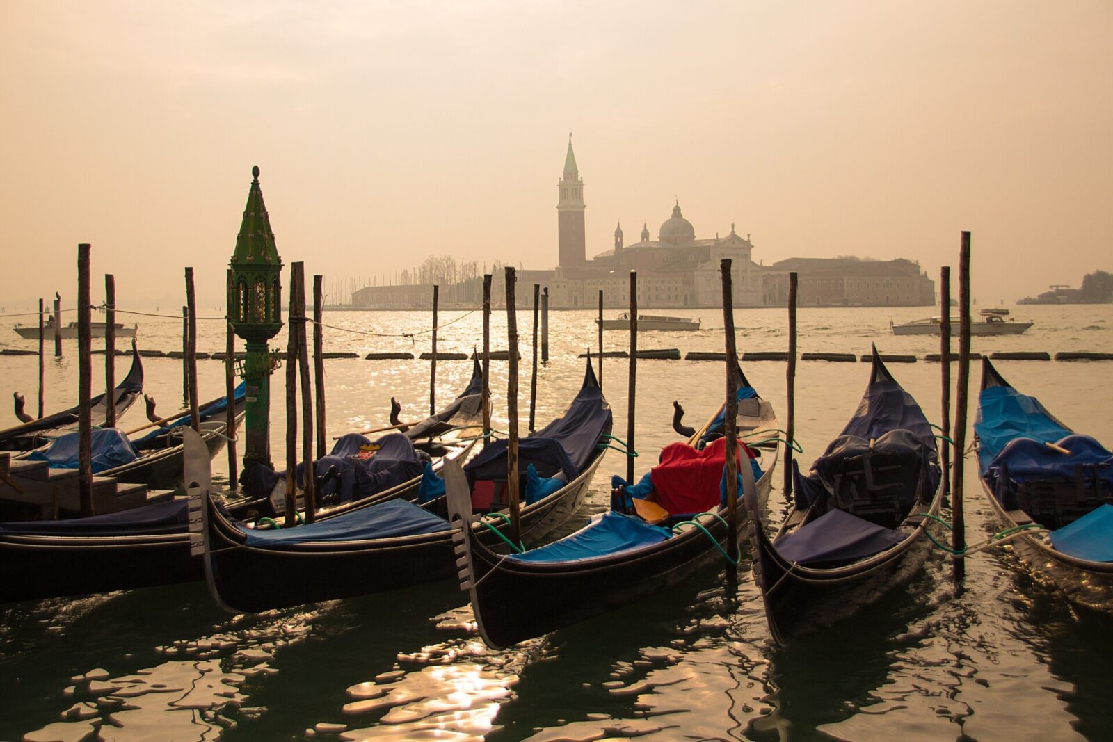 Gondeln in Venedig bei Sonnenuntergang mit Blick auf die Insel San Giorgio Maggiore und ihre beeindruckende Basilika.