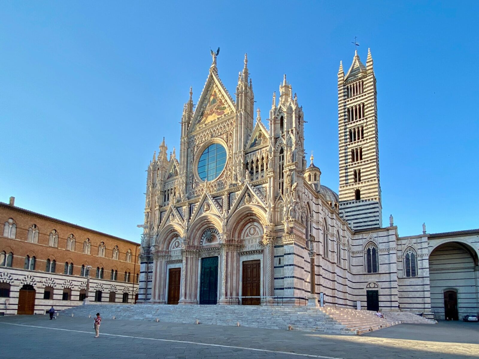 Der Dom von Siena, eine beeindruckende gotische Kathedrale mit kunstvoller Fassade und markantem Glockenturm.
