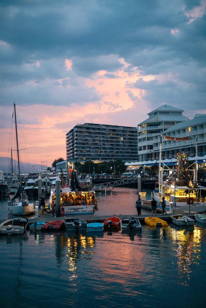 Fischereihafen bei Sonnenuntergang mit Booten und frischem Seafood in tropischer Stadt