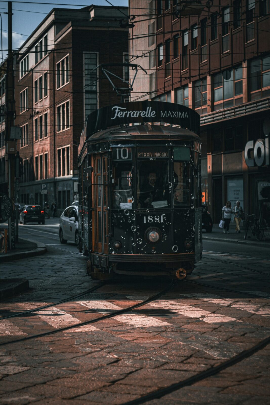 Historische Straßenbahn in Mailand auf einer urbanen Straße bei stimmungsvoller Beleuchtung.