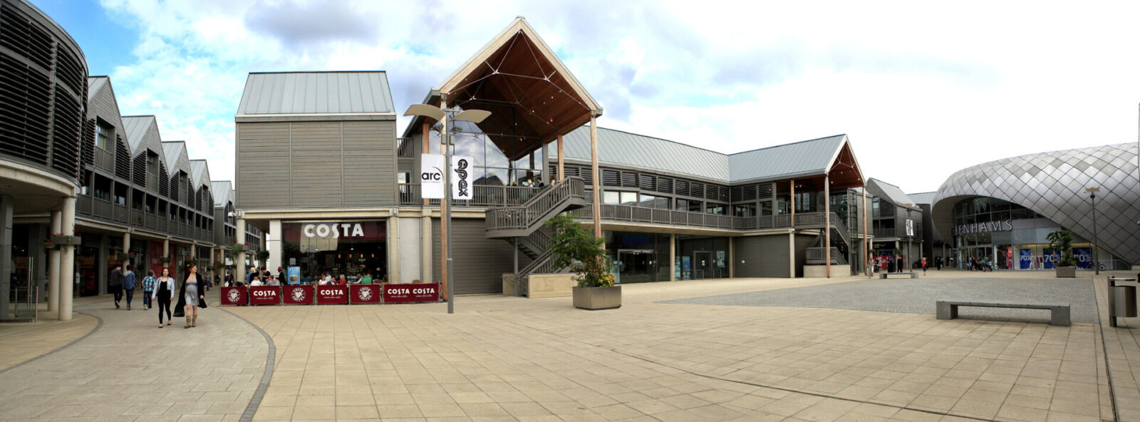 Modernes Einkaufszentrum mit offenen Gehwegen, Geschäften und einem Costa Coffee Café.