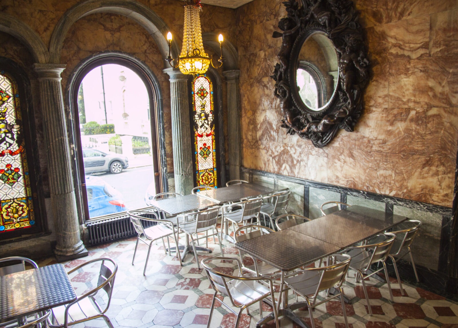 Historisches Café mit Marmordekor, Buntglasfenstern und Kronleuchter.